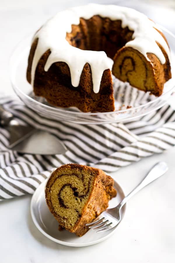 A slice of Cinnamon Bundt Cake with the whole cake in the background