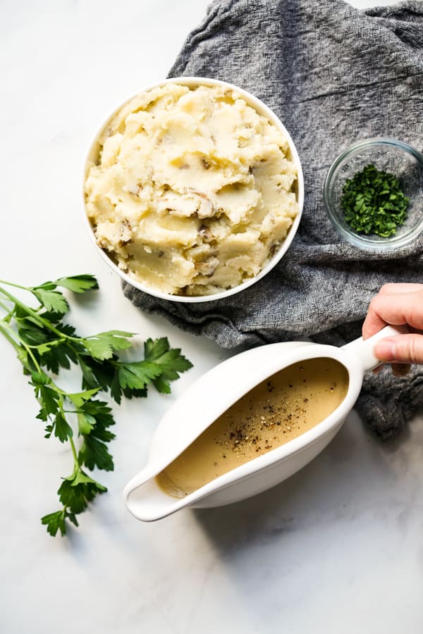 Gravy boat with brown gravy and mashed potatoes on the side