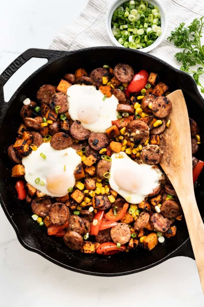 Top down view of a sweet potato sausage bell pepper hash with overeasy eggs on top