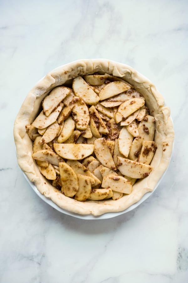 Unbaked apple pie filled with sliced apples