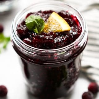 A jar of cranberry sauce with orange slices on top