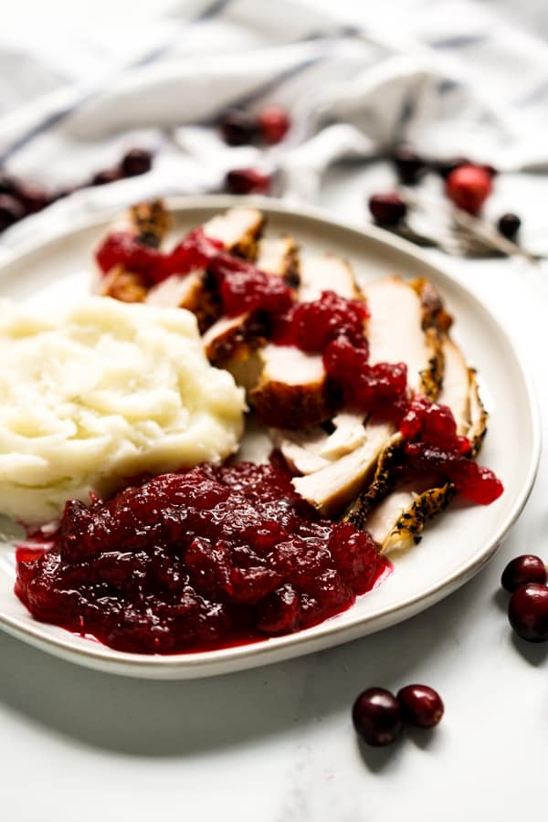 A plate of turkey and mashed potatoes with cranberry sauce