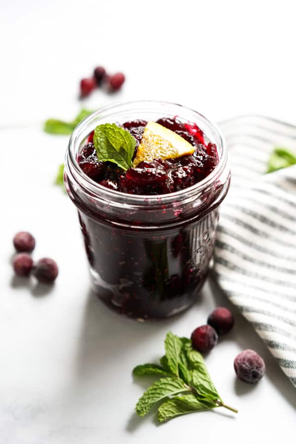 A bowl of cranberry sauce with a spoon in it