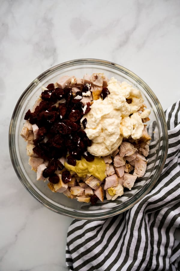 A bowl of chopped leftover turkey with mayo, dijon mustard, dried cranberries, and lemon juice