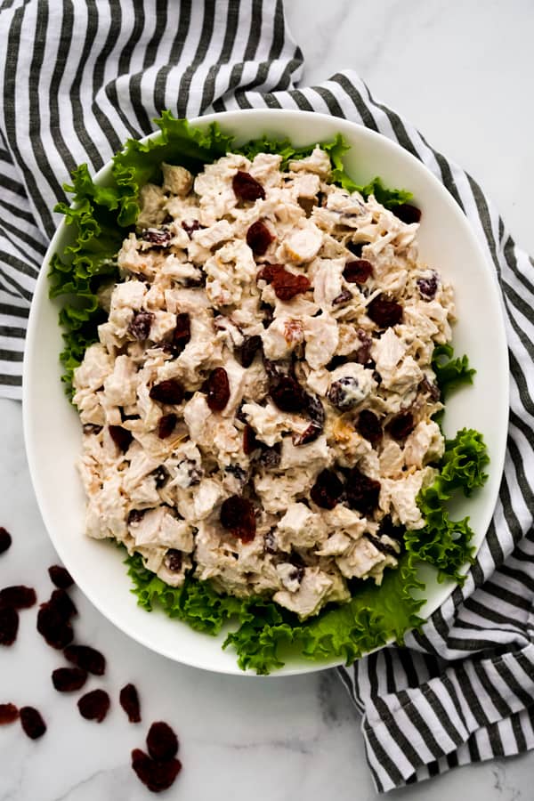 A rectangular plate of turkey salad decorated with green lettuce