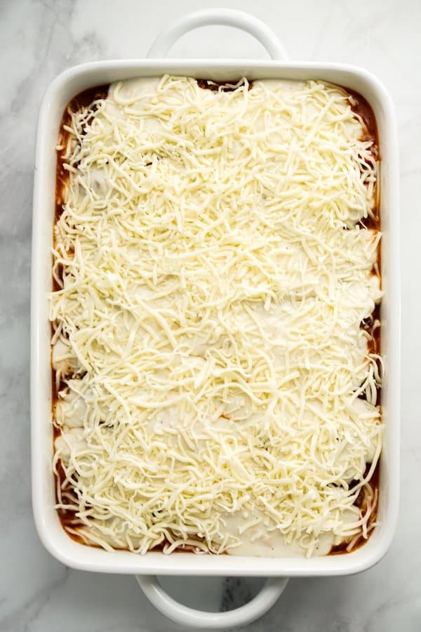 Topping lasagna off with shredded mozzarella cheese