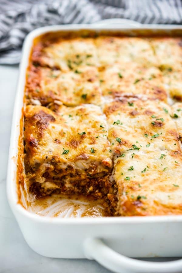 A large pan of lasagna layered with bolognese sauce, bachemel sauce and topped with melted mozzarella cheese