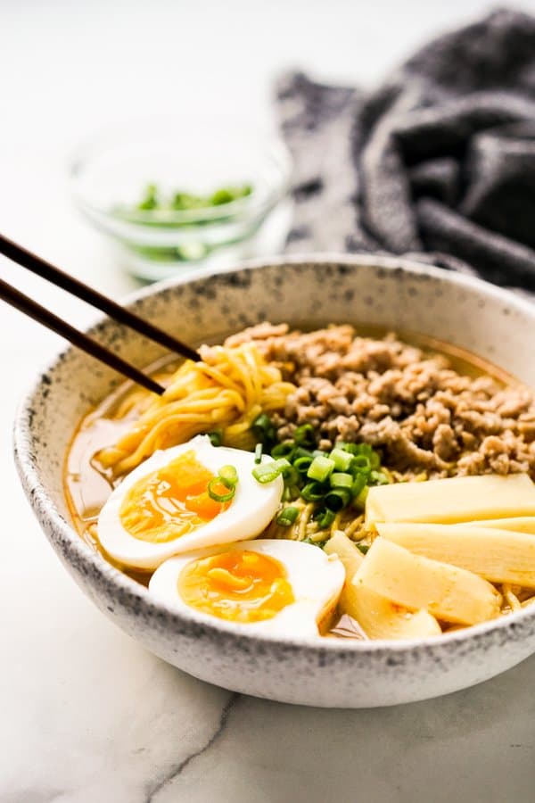 Chopsticks sticking into a bowl of noodles