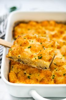 Lifting up tater tot breakfast bake out of the casserole dish