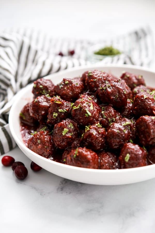 A bowl of meatballs covered with cranberry sauce