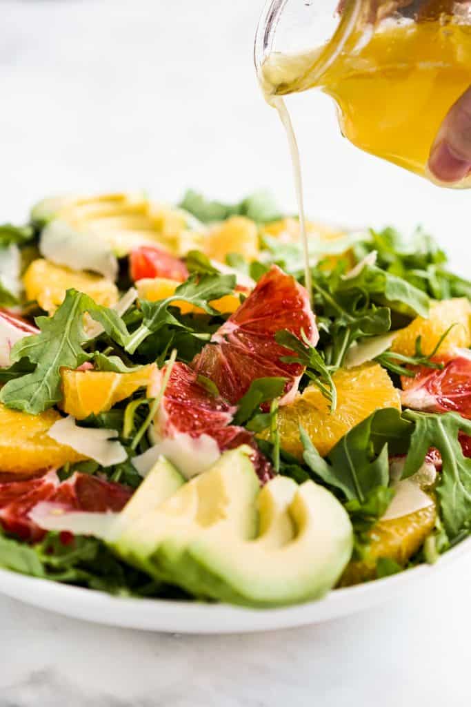 Drizzling lemon dressing onto salad