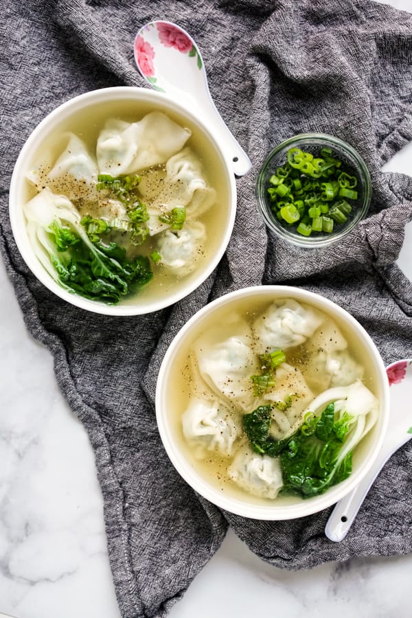 Top down view of two bowls of wonton soup