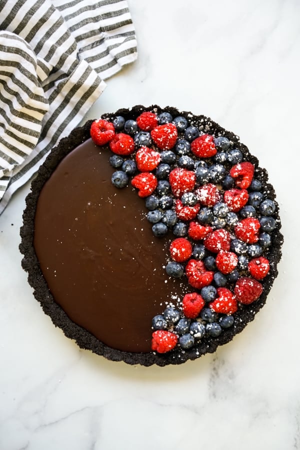 Top down view of dark chocolate tart topped with berries
