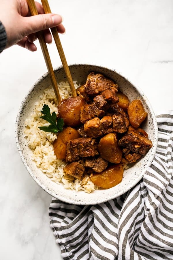 Chopsticks digging into a bowl of Chinese Braised BBQ Pork with potatoes