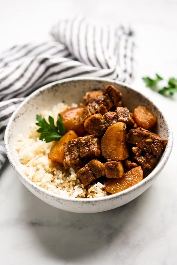 a bowl of braised pork belly and potatoes in soy sauce