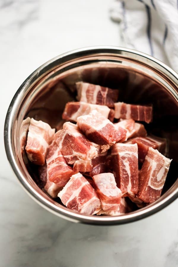 A bowl of uncooked sliced pork belly