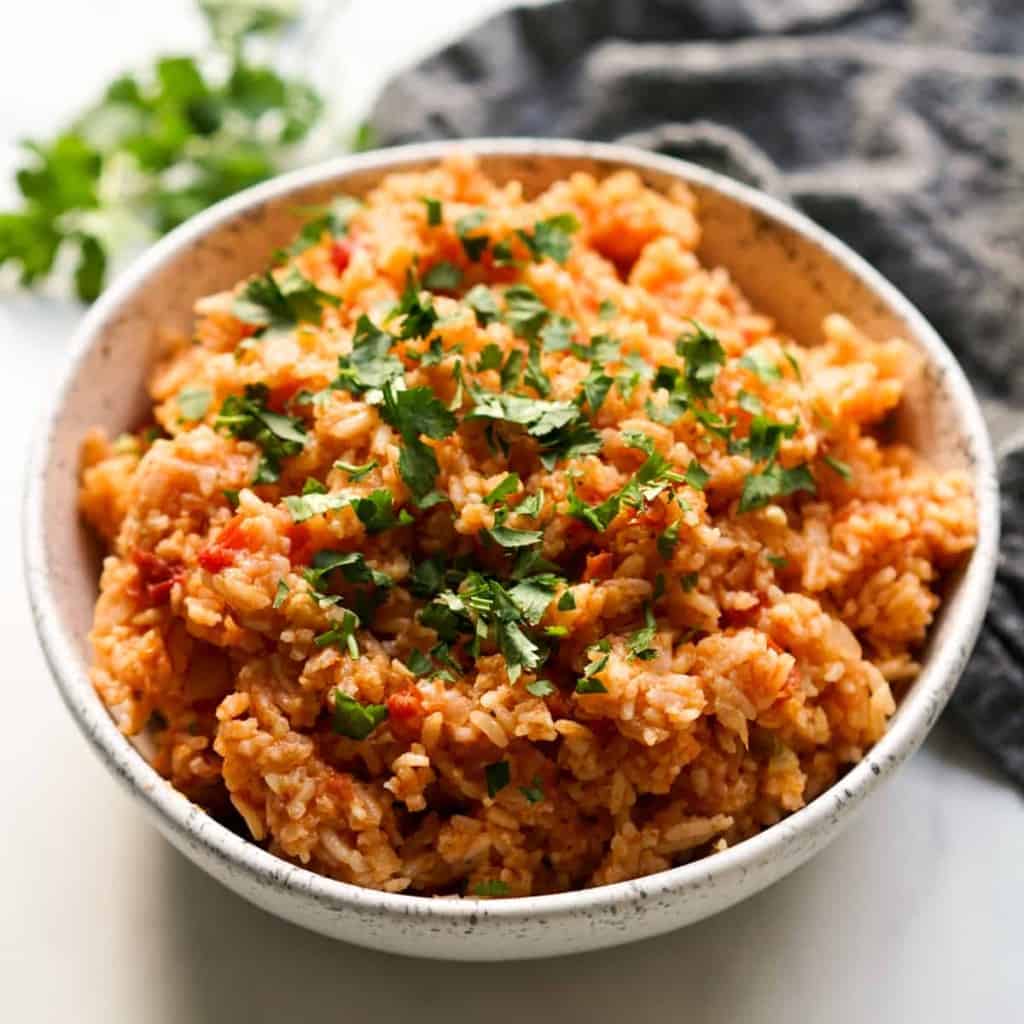 A bowl of seasoned mexican rice with small chunks of tomatoes
