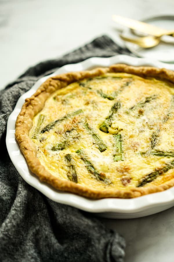 A round plate of quiche with asparagus