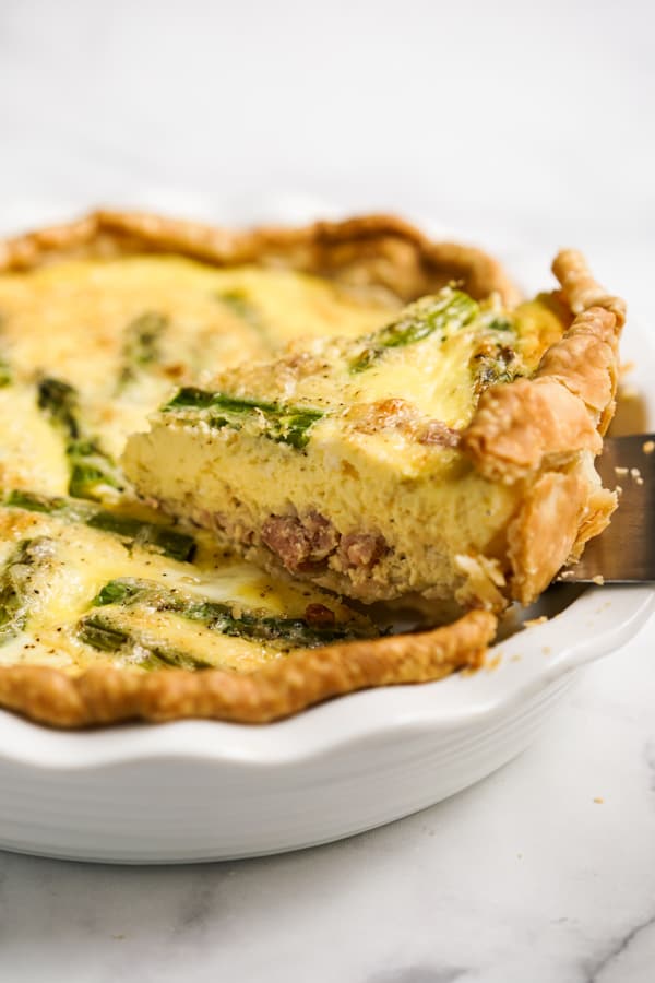 Lifting up a slice of Asparagus and Ham quiche