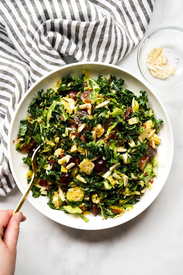 Fork digging into a bowl of Kale and Brussels Sprouts Salad