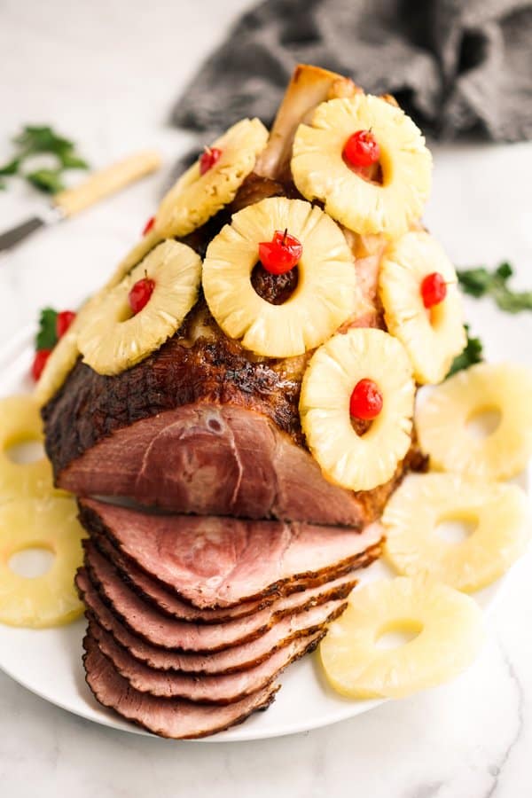 Large baked ham covered with pineapple with a few slices sliced out