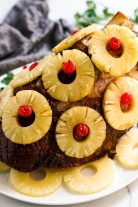 Baked whole ham covered in pineapple rings and cherries
