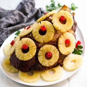 Baked whole ham covered in pineapple rings and cherries