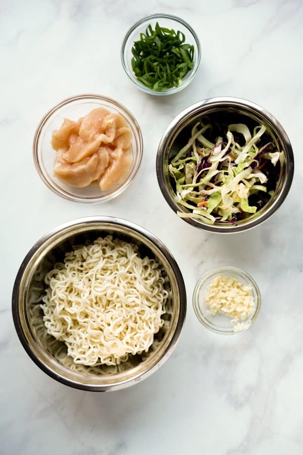 Small bowl o green onions, chicken slices, cabbage, ramen noodles, and garlic