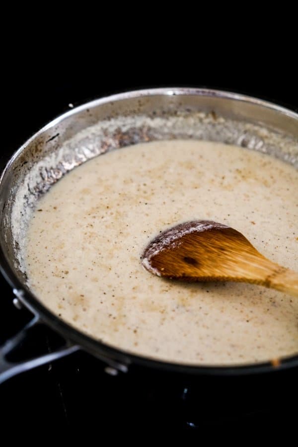 Cooking creamy lemon garlic sauce in skillet