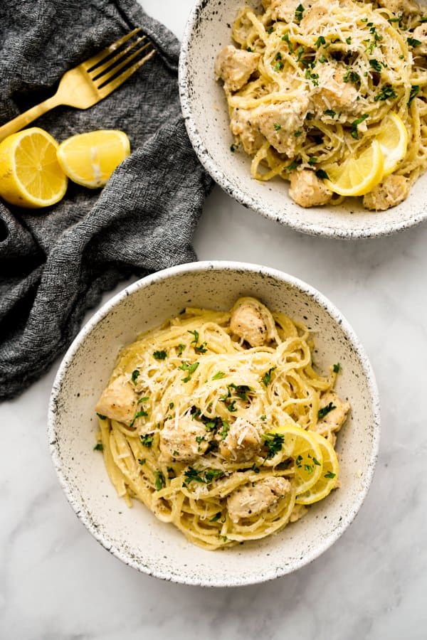 Two bowls of Creamy Lemon Chicken Pasta topped with parmesan and chopped parsley