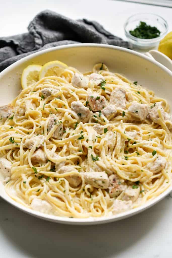 A skillet loaded with creamy pasta tossed in lemon sauce and chicken