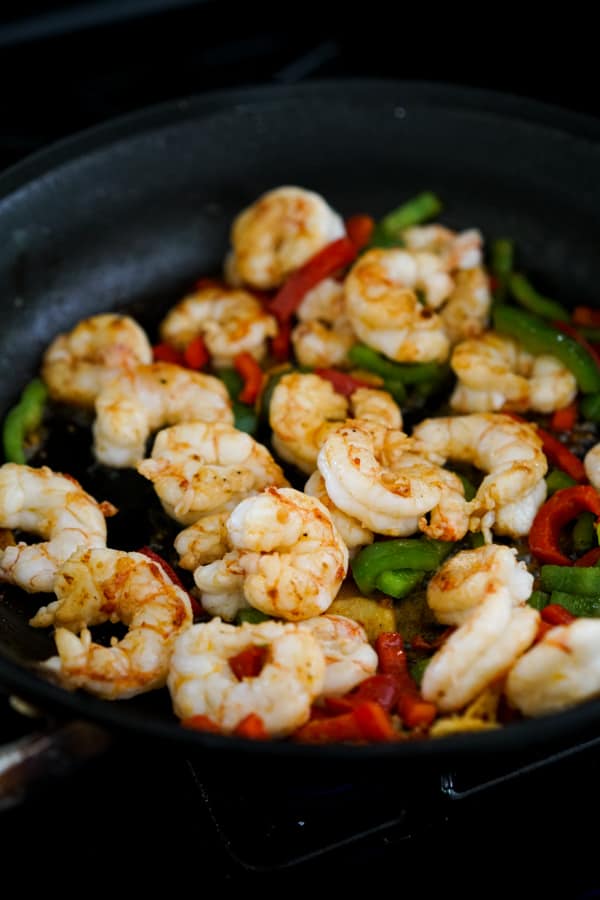 Searing shrimp and bell peppers in a skillet