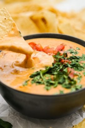 Dipping chip into a bowl of queso