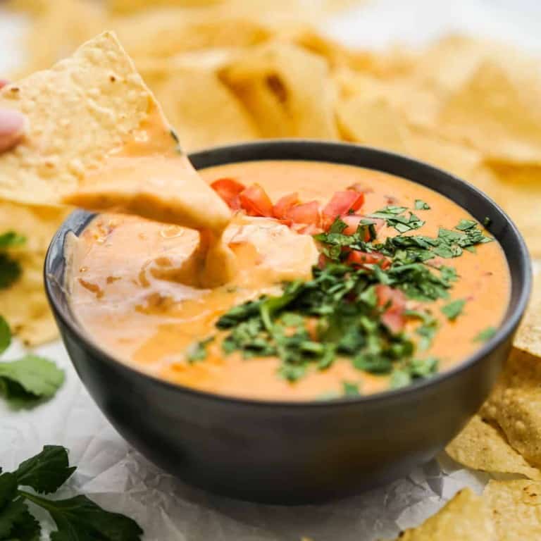 Dipping chip into a bowl of queso