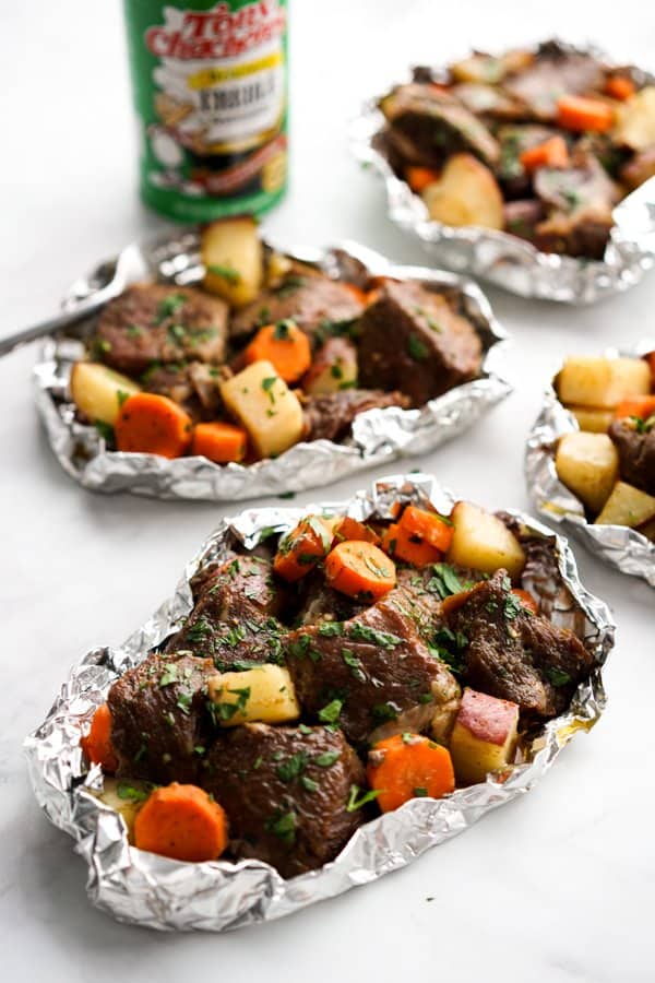 Packets of Steak and Potato Foil Packs with creole seasoning in the background