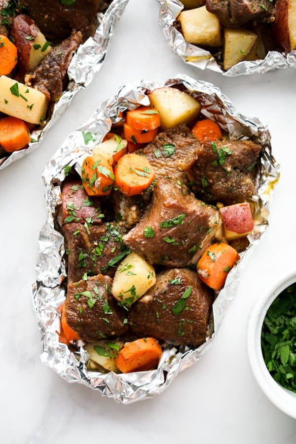 Steak, potatoes and carrots in foil pack