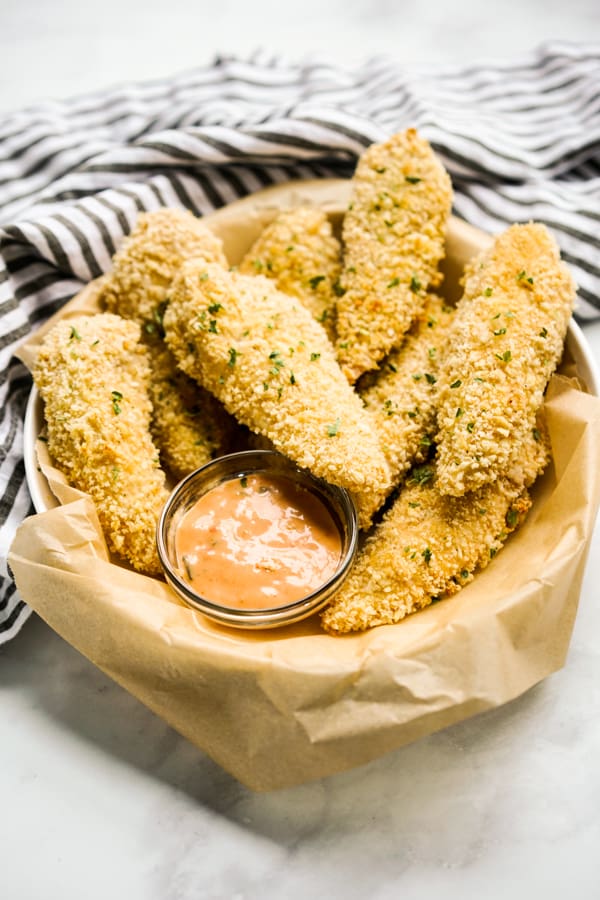 Panko Baked Chicken Tenders in a round bowl with sauce on the side