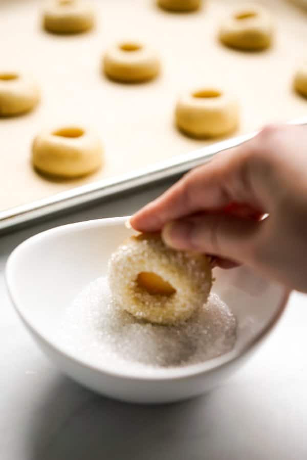 Dipping indented shortbread cookie dough into sugar crystals