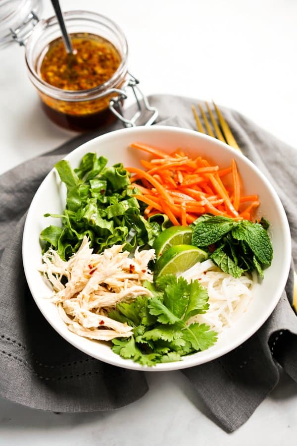 A bowl of Vietnamese Rice Noodle Salad with Dressing in the background