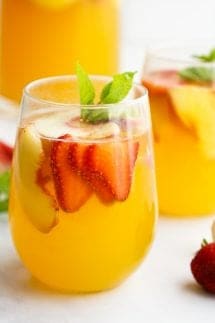 White Sangria with slices of peaches and strawberries