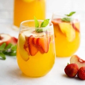 White Sangria with slices of peaches and strawberries
