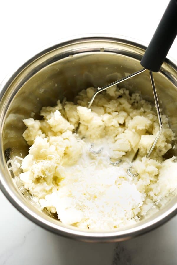 Adding cream, mascarpone cheese, parmesan cheese to mashed potatoes