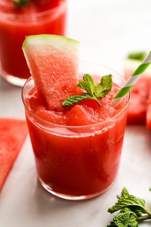 A glass of watermelon slush with a straw