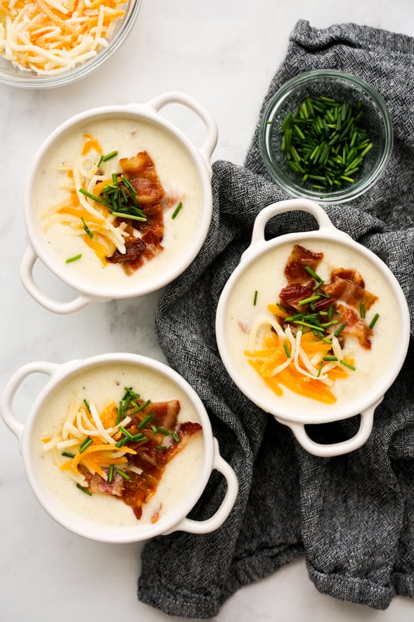 Top down view of three bowls of loaded baked potato soup