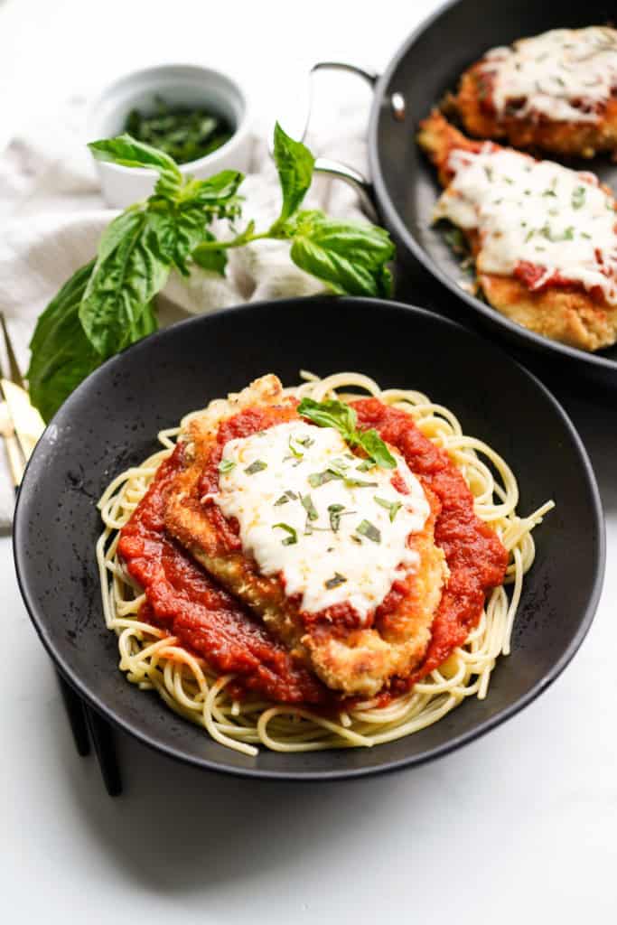 A bowl of spaghetti topped with crispy chicken parm