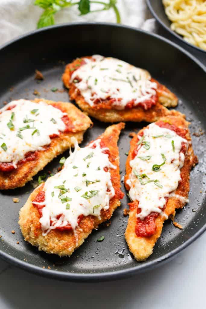 Skillet chicken parmesan topped with marinara sauce and melted cheese