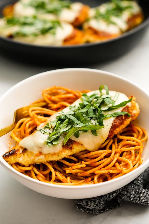 A bowl of spaghetti topped with chicken parm