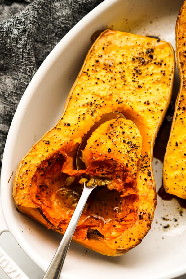 Scooping out a spoonful of Whole Roasted Butternut Squash