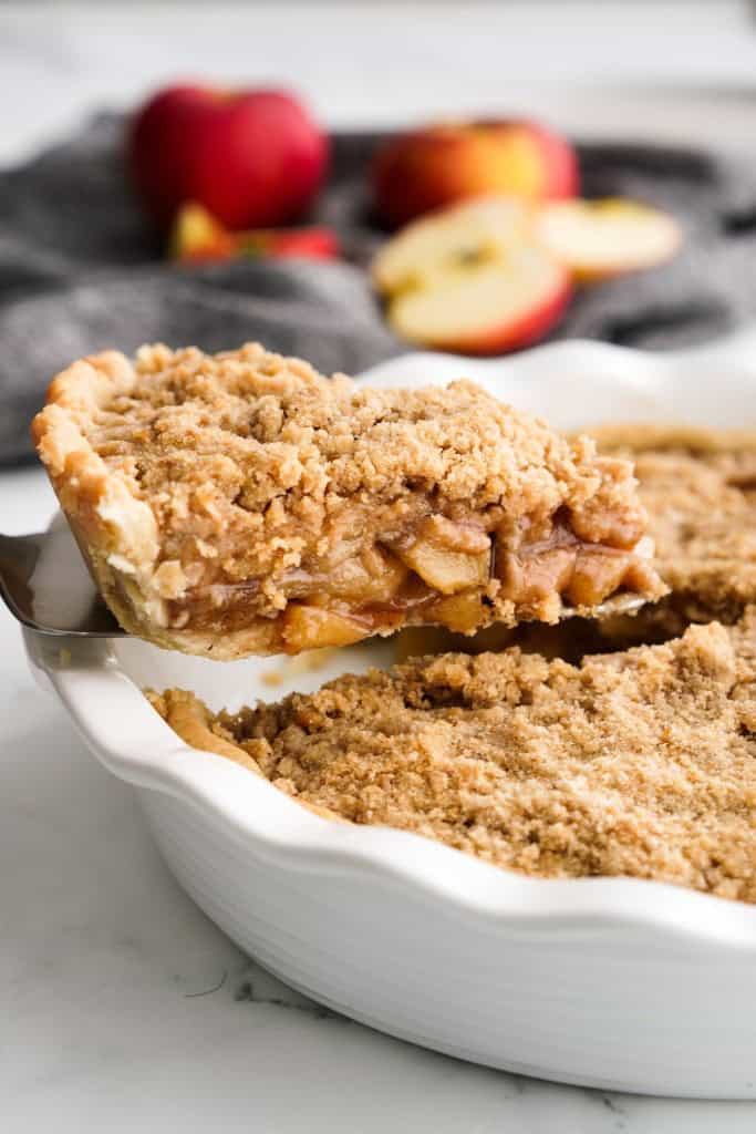 Lifting up a slice of Dutch apple pie out from the pie pan