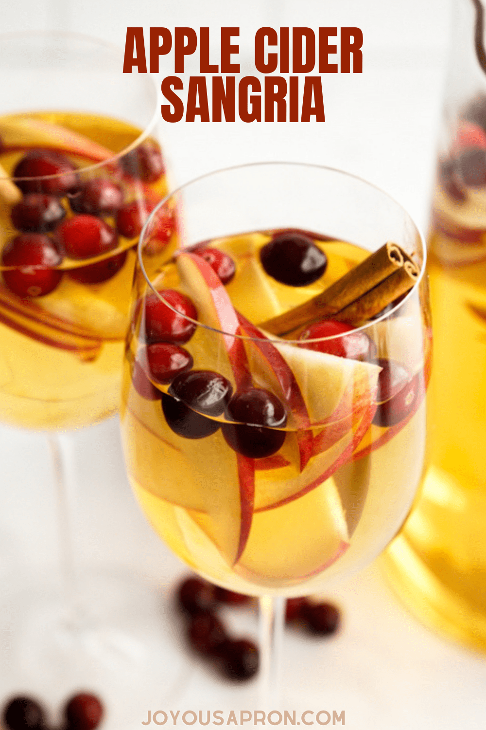 Apple Cider Sangria - A Fall and holiday inspired alcoholic beverage and drink! This cocktail combines apple cider, white wine, a splash of brandy, club soda, apples, cranberries and cinnamon. via @joyousapron